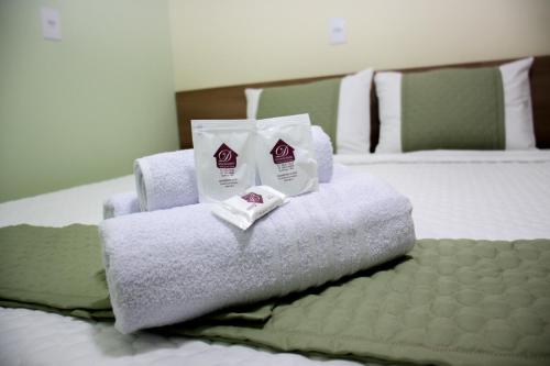a pile of towels sitting on top of a bed at Domus Hotel Cidade Nobre - Ipatinga in Ipatinga