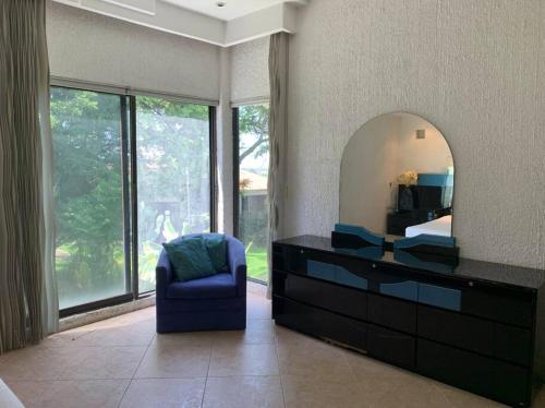 a bedroom with a dresser with a mirror and a chair at Brisas el Valle in Temixco