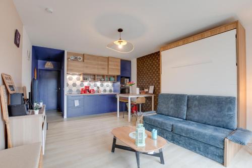 un salon avec un canapé bleu et une table dans l'établissement Gîte des randonneurs de la Presqu'île de Lézardrieux Bretagne, à Lézardrieux