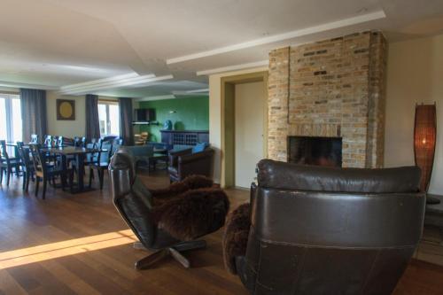 a living room with a couch and a fireplace at St-Janshof Hotel in Waregem