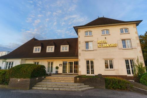 a large building with a hotel sign on it at St-Janshof Hotel in Waregem