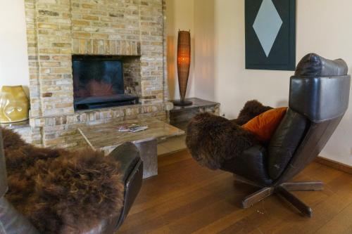 a living room with a chair and a fireplace at St-Janshof Hotel in Waregem