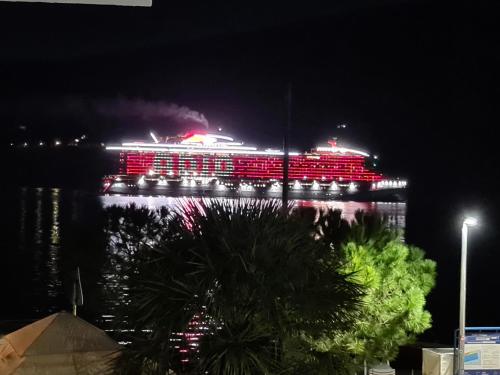ein Kreuzfahrtschiff leuchtet nachts mit roten Lichtern in der Unterkunft Milinovic apartmani1 in Herceg-Novi