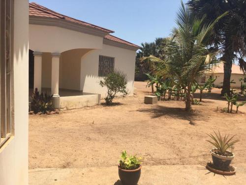 a yard with some plants and a building at Carl and Veronica Guest House in Sanyang