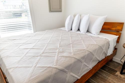 a bedroom with a bed with white sheets and pillows at HTR TX Hill Country Campground in Kerrville