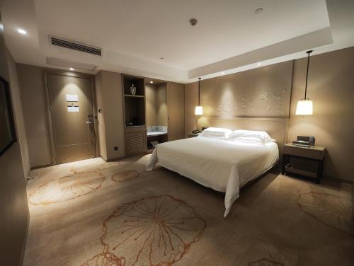 a bedroom with a large white bed in a room at Byland Star Hotel in Yiwu