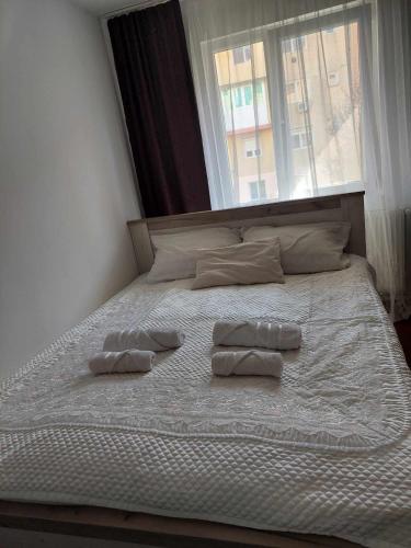 a bed with two pillows on it with a window at A&D in Reşiţa