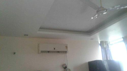a room with a ceiling fan and a window at OYO Naveen Residancy in Gurgaon