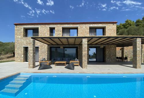 a villa with a swimming pool in front of a house at The Mavrolitharo Residence in Akti Salonikiou