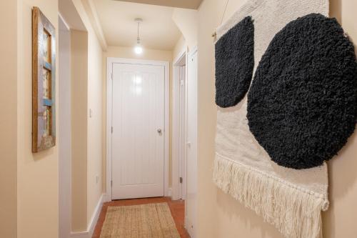 a hallway with a white door and a wall at 8 Booth Court in Glossop