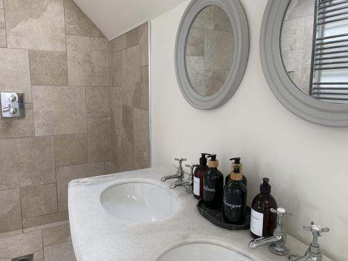 a bathroom with a sink with wine bottles on it at Caramel Cottage at The Bay Filey, sleeps 6, 2 dogs welcome for free too in Filey