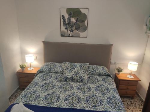 1 dormitorio con 1 cama con 2 lámparas en las mesas en Casita La Playa, en Málaga