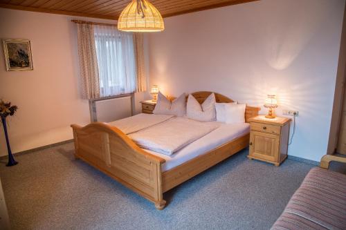 1 dormitorio con 1 cama grande de madera y 2 lámparas en Maurerhof en Ruhpolding