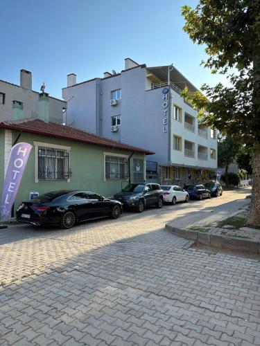 埃迪爾內的住宿－Well Hotel Edirne，停在大楼前的一组汽车