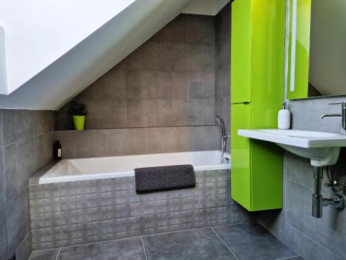 a bathroom with a bath tub and a sink at CHALET HOUBOVÝ VRCH in Horní Planá