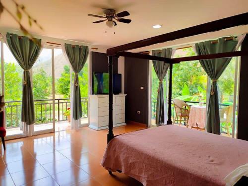a bedroom with a bed with a television and a balcony at Zoila's Suite Escape in Nuevo Tingo
