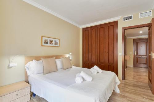 a bedroom with a large white bed with towels on it at Star City in Málaga