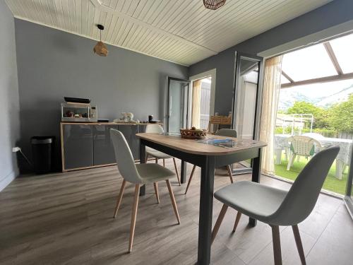 une cuisine et une salle à manger avec une table et des chaises dans l'établissement Maison du plateau de beille, aux Cabannes