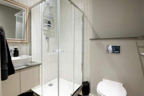 a bathroom with a shower with a toilet and a sink at Stunning 902 Florida Road in Durban
