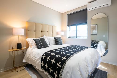 a bedroom with a large bed and a large mirror at Stunning 902 Florida Road in Durban