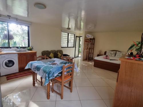 a kitchen and living room with a table and a couch at Fare alizés in Mahina
