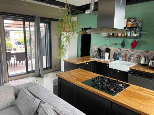 een keuken met een aanrecht en een fornuis bovenste oven bij Loft sur les toits de Roubaix in Roubaix