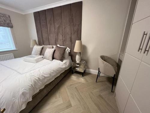 a bedroom with a white bed with a wooden headboard at Luxurious apartment in Central London in London