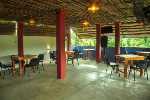 a room with tables and chairs and a flat screen tv at Airport Tourist Resort in Katunayake