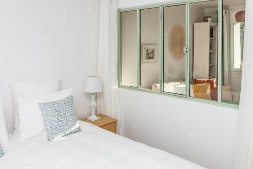 a bedroom with a white bed and a window at Gîtes Isatis in Arbonne-la-Foret