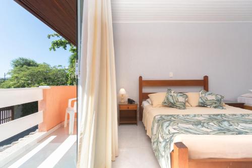 Cet appartement comprend une chambre avec deux lits et un balcon. dans l'établissement Pousada Marbella Inn, à Búzios