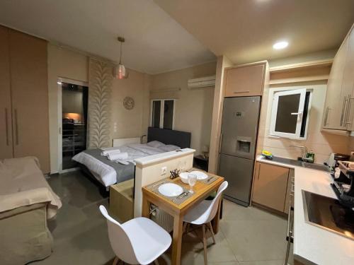 1 dormitorio con cama, mesa y cocina en AIOLOS VOULA near the sea apartment en Atenas