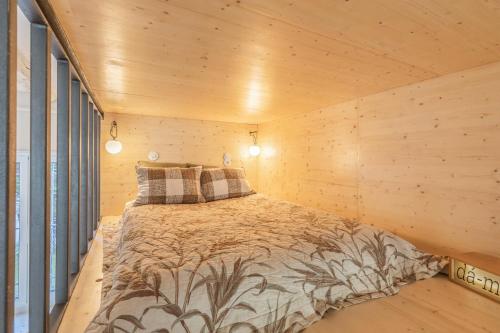 une chambre avec un lit dans un mur en bois dans l'établissement Loft in Pernety, à Paris