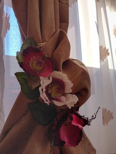um ramo de flores sentado em cima de uma cortina em Casa Danut em Reşiţa