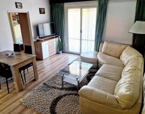 een woonkamer met een bank en een tafel bij Villa Felícia in Balatonszepezd