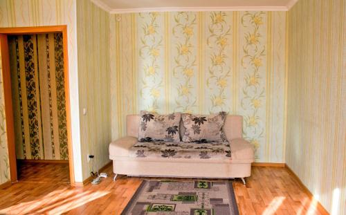 ein Wohnzimmer mit Sofa und Tapete in der Unterkunft Нью-Йорк in Petropawlowsk