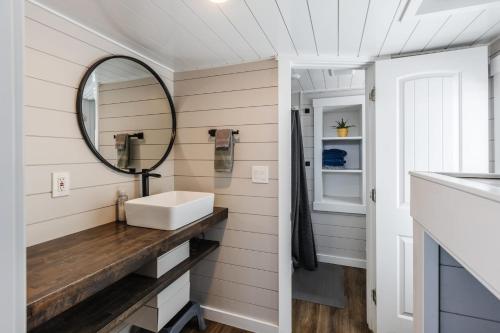 a bathroom with a sink and a mirror at Lil' Blue Oasis Tiny Home in Apple Valley