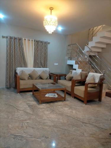 a living room with two couches and a staircase at Sandy Luxury Villa 3 Bhk in Ooty