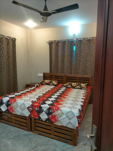 a bedroom with a bed with a comforter on it at Sandy Luxury Villa 3 Bhk in Ooty