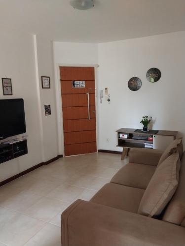 a living room with a couch and a wooden door at APARTAMENTO ITAIGARA in Salvador