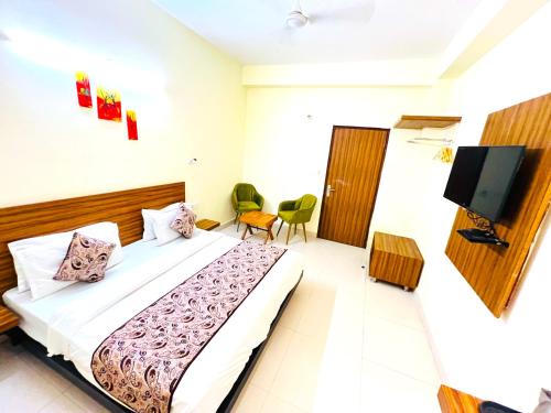 a bedroom with a bed and a flat screen tv at Hotel Ganga Ashoka - Rishikesh in Rishīkesh