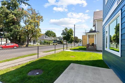 a yard with a fence next to a house at Brand New 3BD 2 5BTH Triplex Unit Near Downtown in Spokane