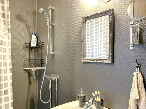 ein Bad mit einer Dusche, einem Waschbecken und einem Spiegel in der Unterkunft Holiday home SVENLJUNGA in Tranemo