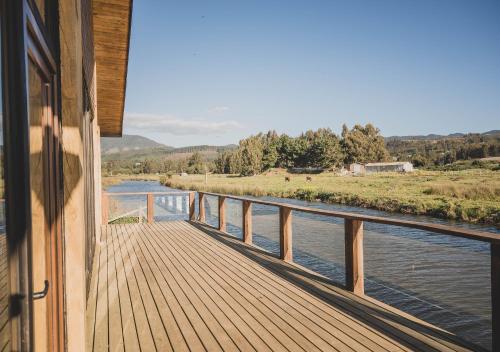 a view from the porch of a house overlooking a river at Hotel Puerto Madera in Pelluhue