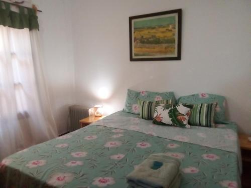 1 dormitorio con 1 cama con edredón verde en La Laurina Casa de Campo Hotel/Hospedaje en Villa Lonca