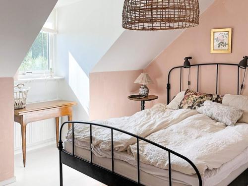 a bedroom with a bed and a table and a window at 4 star holiday home in TOMELILLA-By Traum in Tomelilla