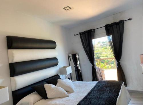 - une chambre avec un lit noir et blanc et une fenêtre dans l'établissement RURAL SUITE LA MORERA, à Las Palmas de Gran Canaria