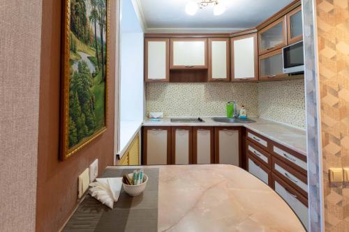 a kitchen with wooden cabinets and a table at Палермо in Petropavlovsk