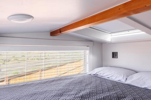 a bedroom with a bed and a large window at Moonrise Tiny Home in Apple Valley