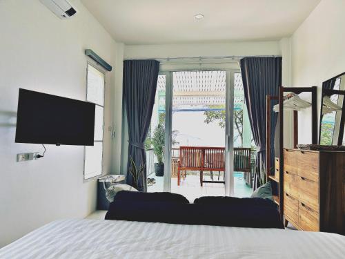 una camera da letto con un letto e una TV a schermo piatto di Villa Ashiana - Jungle Seaview a Ban Chalok Lam