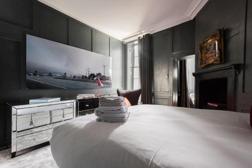a bedroom with a bed with a tv on the wall at Welcome London Soho in London